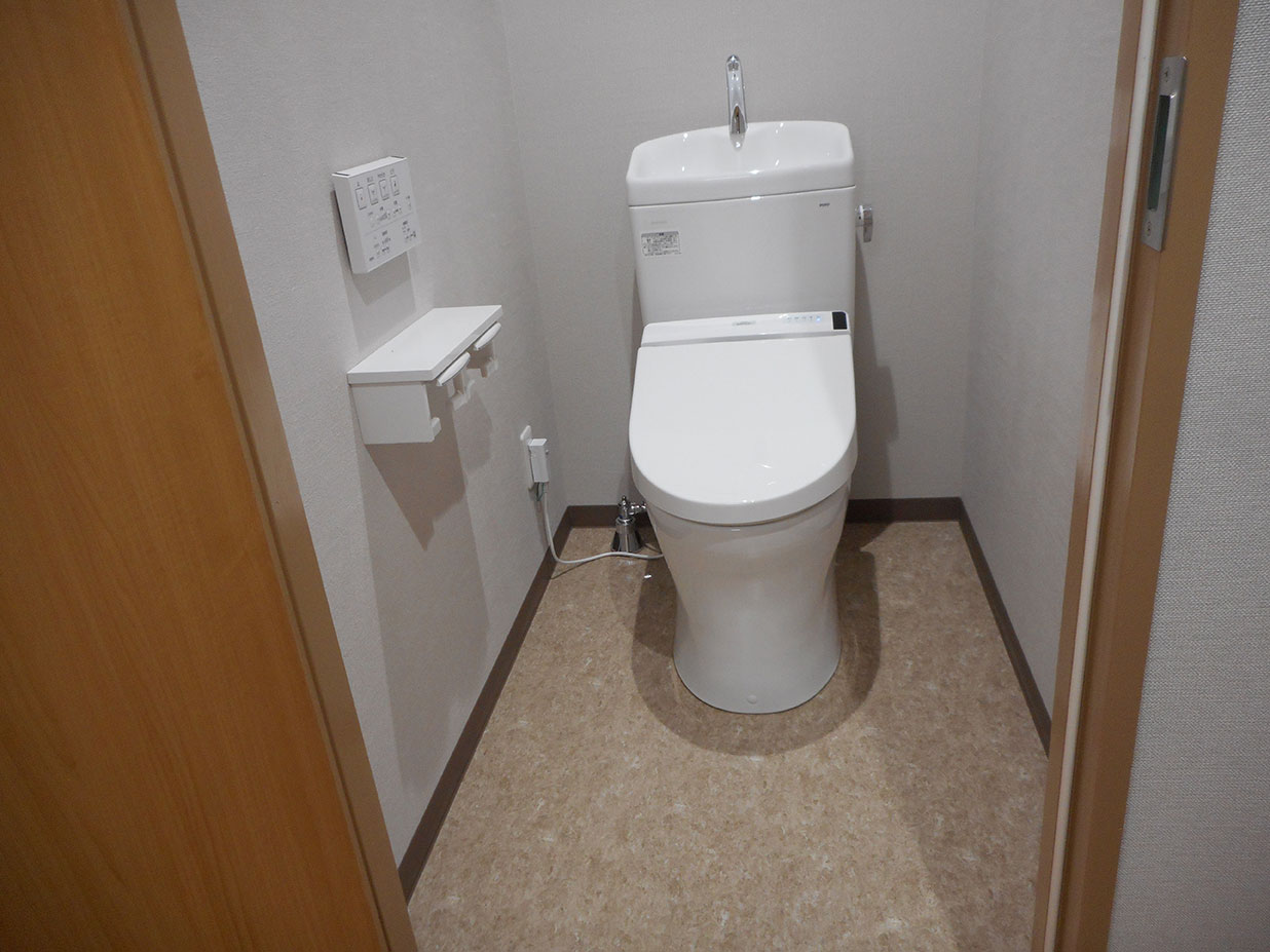 介護施設のトイレ。洋式便器と手洗い器が設置された清潔な個室。